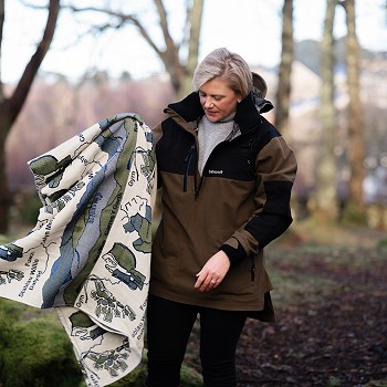 woman in the woods carrying a blanket