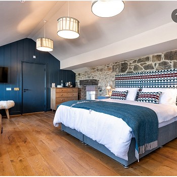 a modern bedroom with a headboard made by anna at Tyn Llan Llandwrog